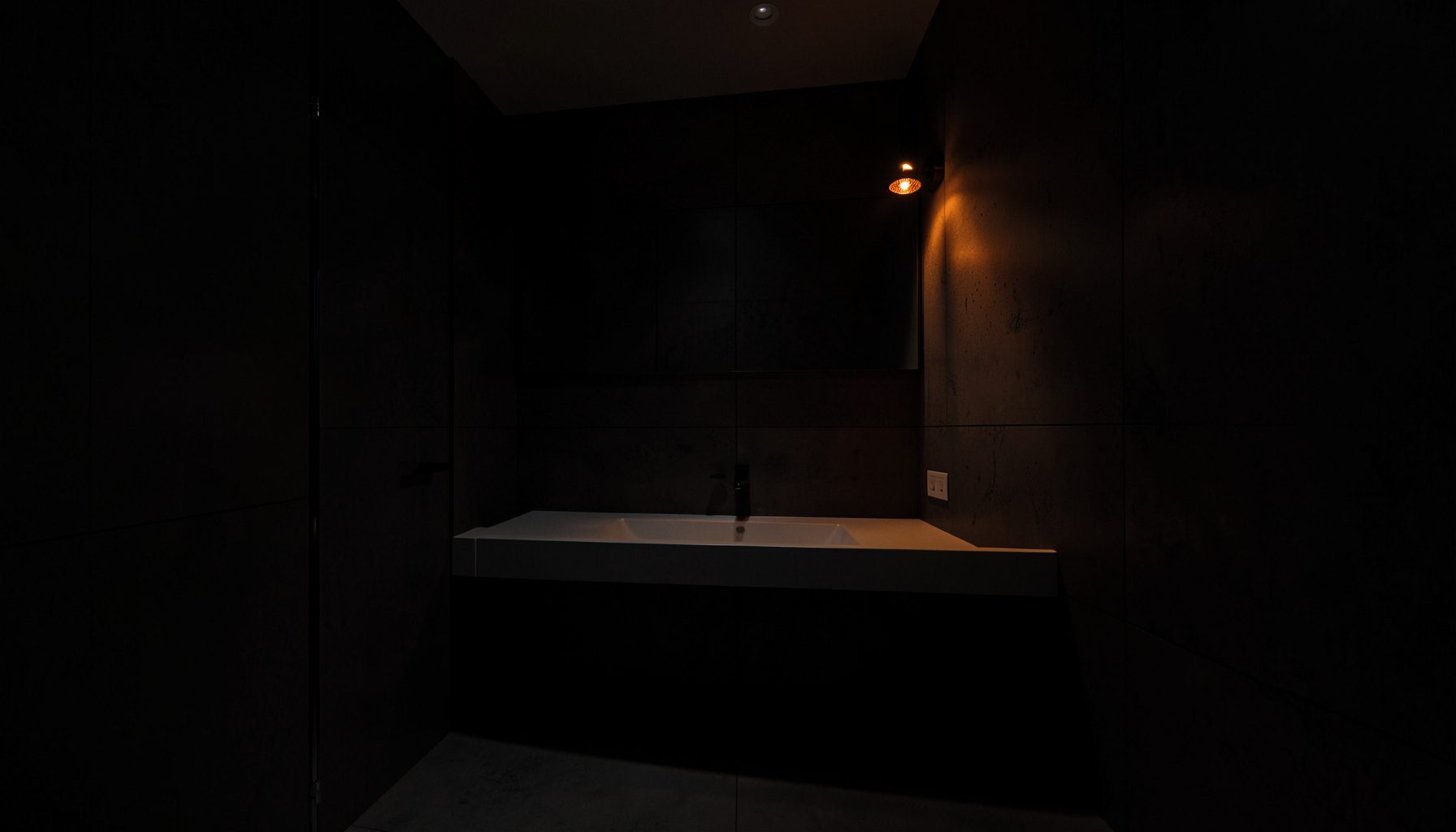 Intérieur de salle de bain contemporaine en lumière tamisée, vasque en pierre au premier plan